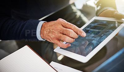 Buy stock photo Cropped shot of a businessman using a digital tablet at his work desk