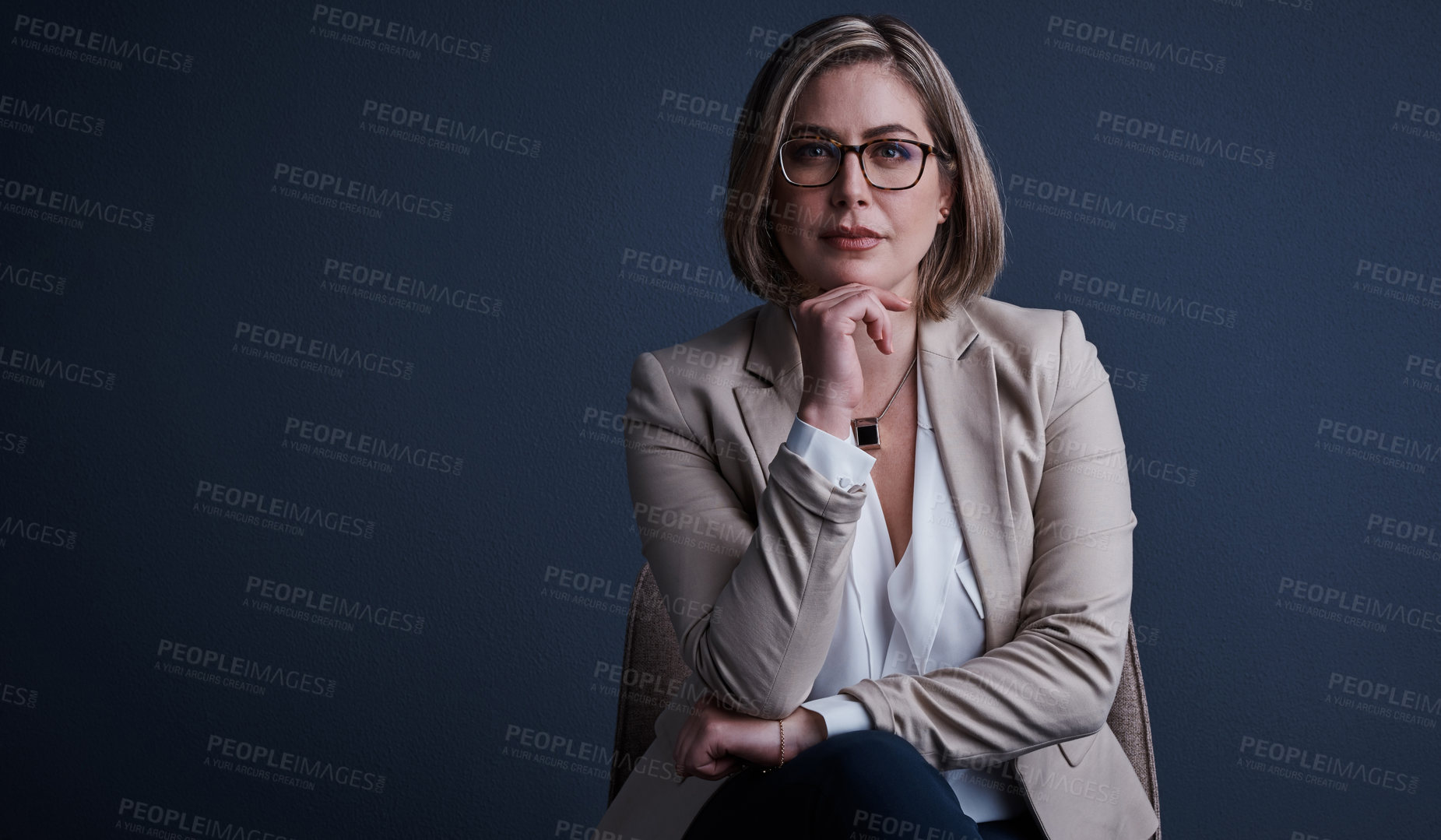 Buy stock photo Studio portrait of an attractive young corporate businesswoman posing against a dark background