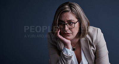 Buy stock photo Studio shot of a young corporate businesswoman looking stressed against a dark background