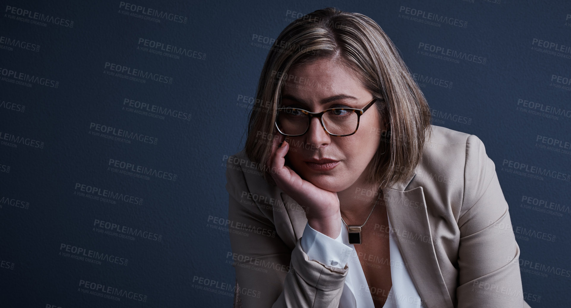 Buy stock photo Studio shot of a young corporate businesswoman looking stressed against a dark background