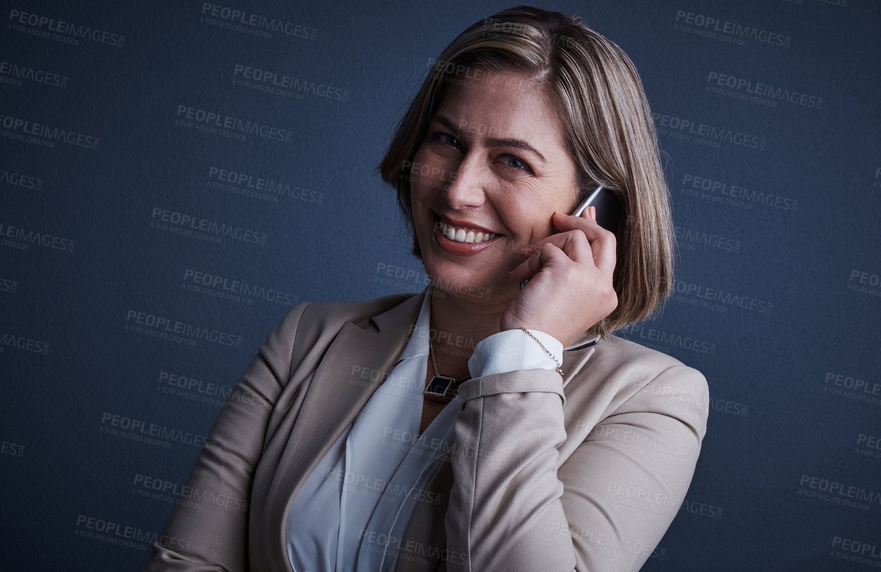 Buy stock photo Studio portrait of an attractive young corporate businesswoman making a call against a dark background