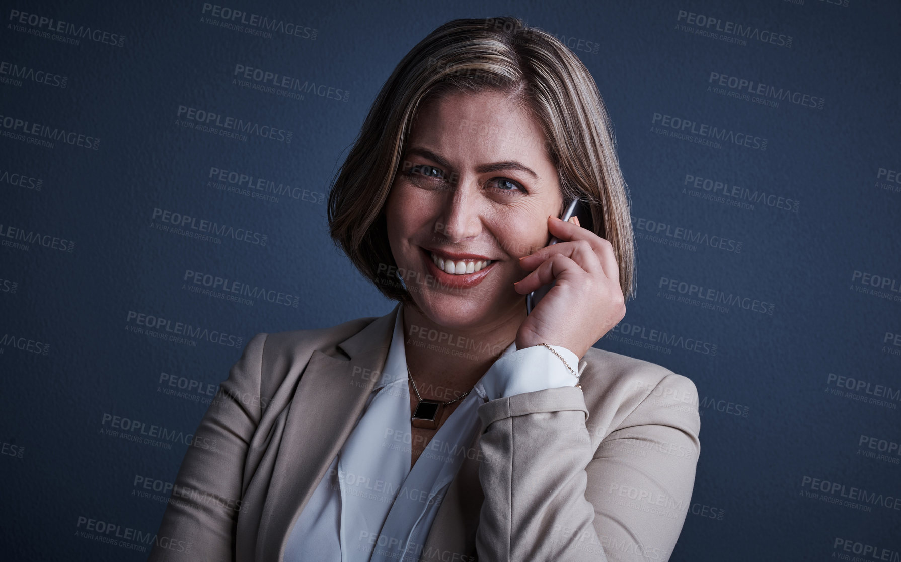 Buy stock photo Studio portrait of an attractive young corporate businesswoman making a call against a dark background