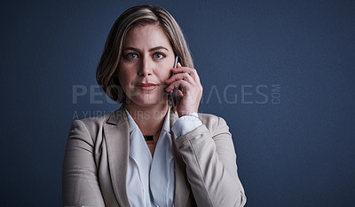 Buy stock photo Studio portrait of an attractive young corporate businesswoman making a call against a dark background