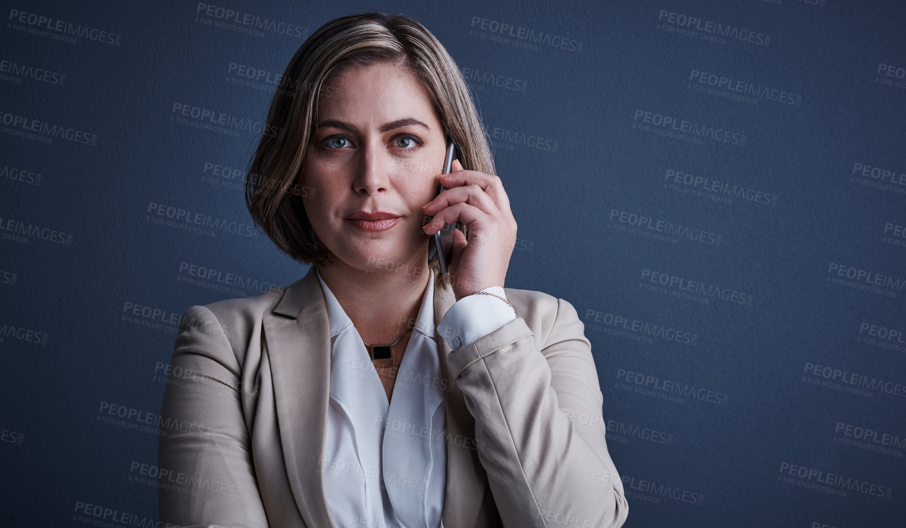 Buy stock photo Studio portrait of an attractive young corporate businesswoman making a call against a dark background