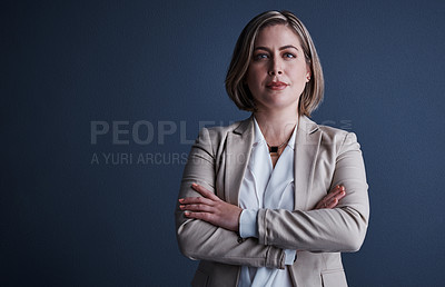 Buy stock photo Studio portrait of an attractive young corporate businesswoman posing with her arms crossed against a dark background