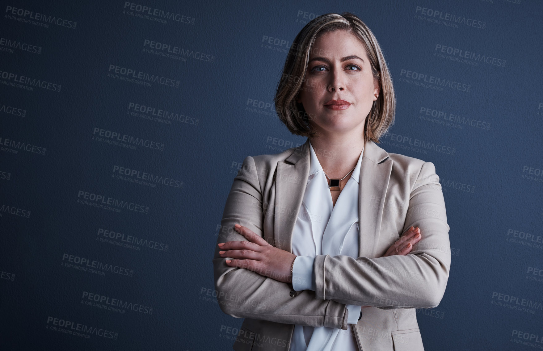 Buy stock photo Studio portrait of an attractive young corporate businesswoman posing with her arms crossed against a dark background