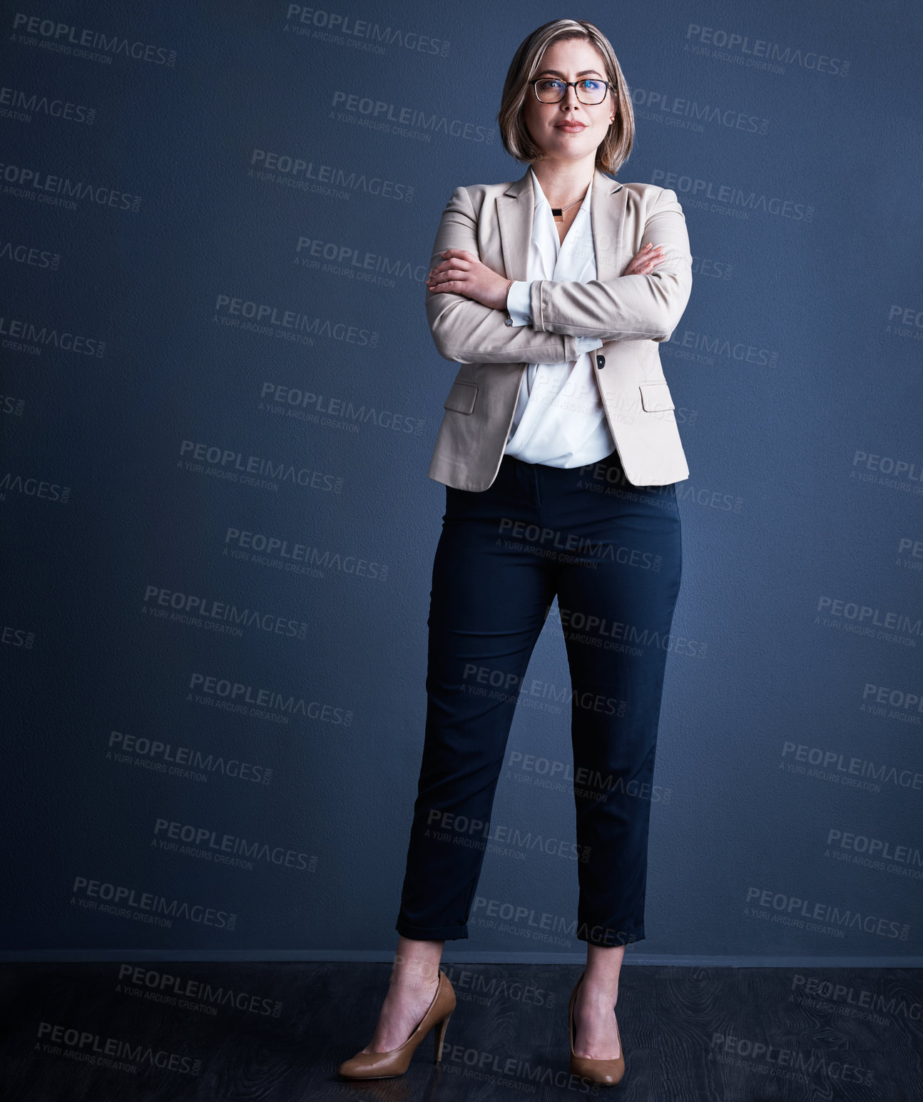 Buy stock photo Studio portrait of an attractive young corporate businesswoman posing with her arms crossed against a dark background