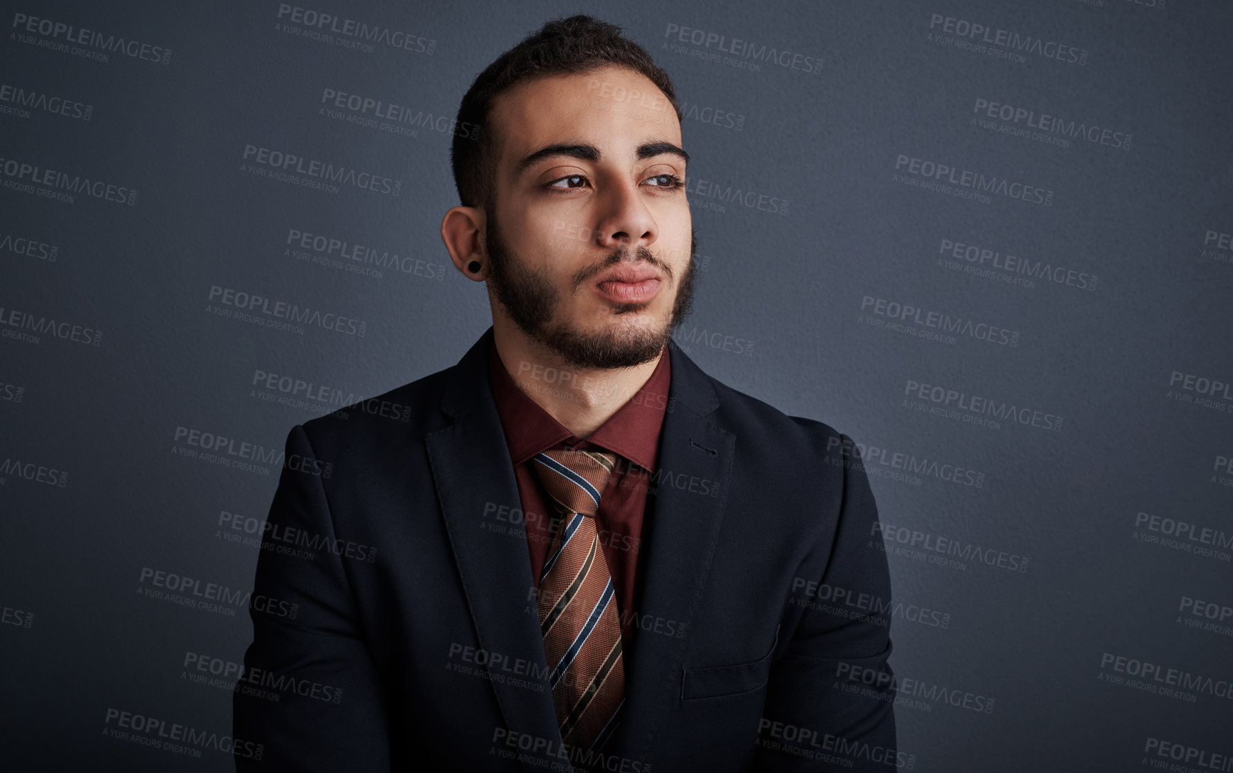 Buy stock photo Studio shot of a stylish young businessman looking thoughtful against a gray background