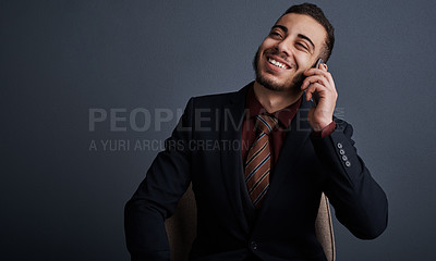 Buy stock photo Studio shot of a stylish young businessman looking thoughtful while making a phonecall against a gray background