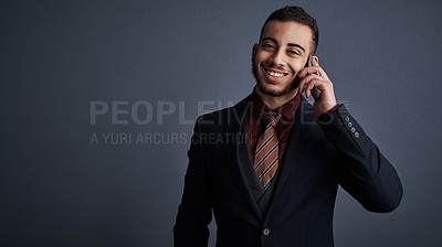 Buy stock photo Studio portrait of a stylish young businessman making a phonecall against a gray background