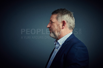 Buy stock photo Studio profile of a confident and mature businessman posing against a dark background