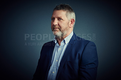 Buy stock photo Studio shot of a confident and mature businessman looking thoughtful against a dark background