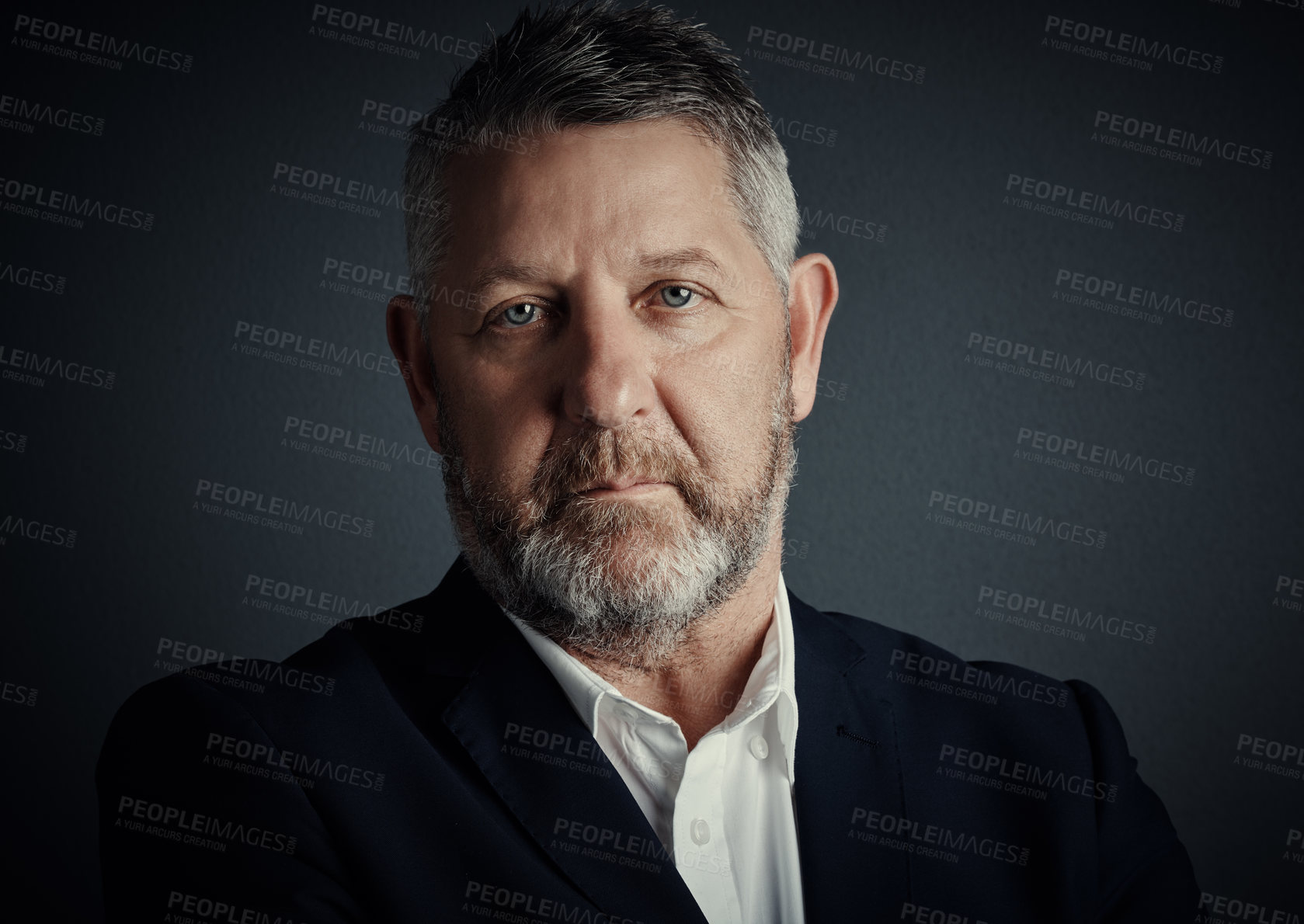 Buy stock photo Studio portrait of a handsome mature businessman standing against a dark background