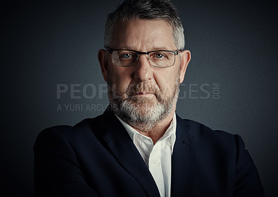 Buy stock photo Studio portrait of a handsome mature businessman standing against a dark background