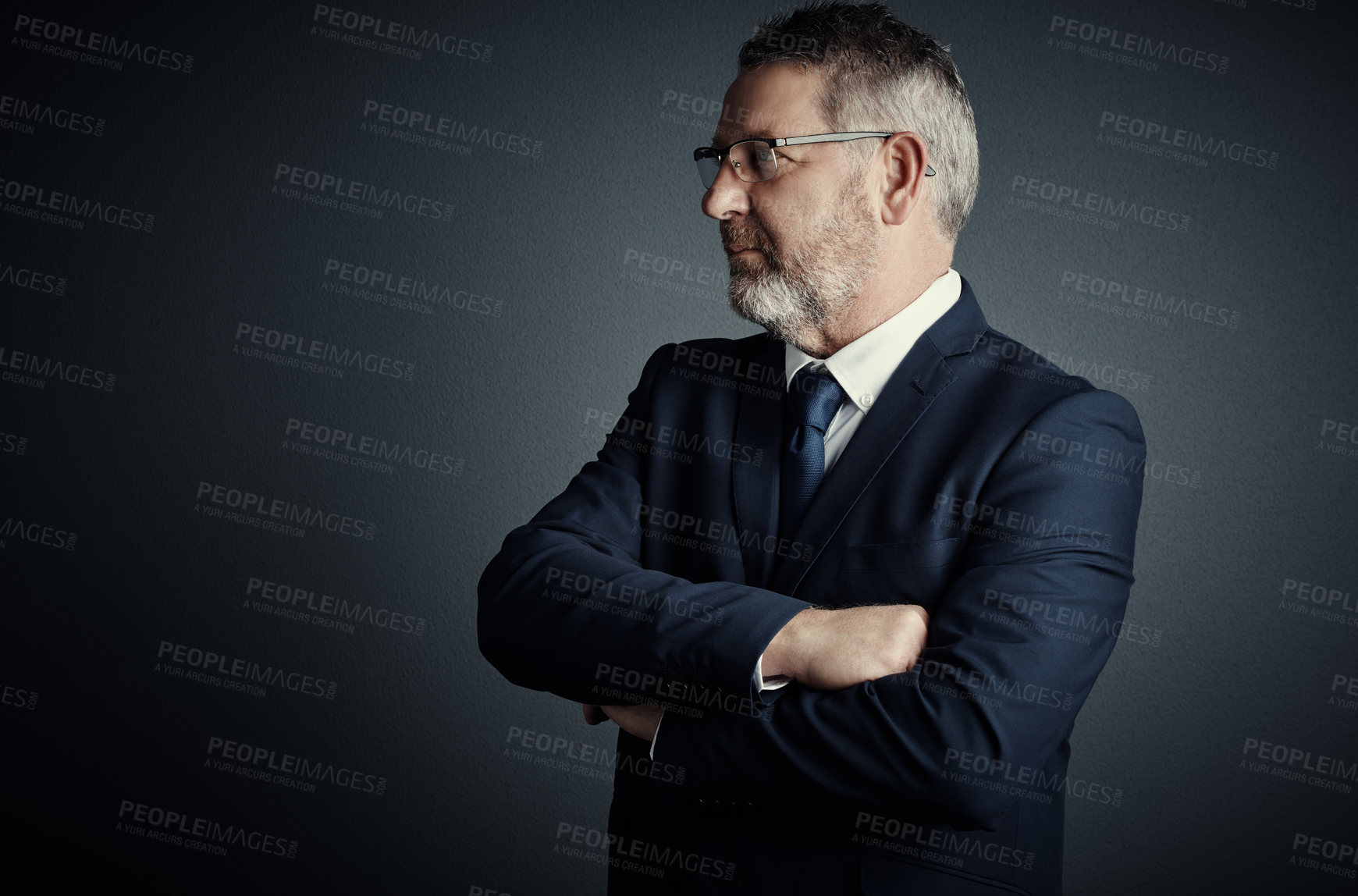 Buy stock photo Studio shot of a handsome mature businessman looking thoughtful while standing with his arms folded against a dark background