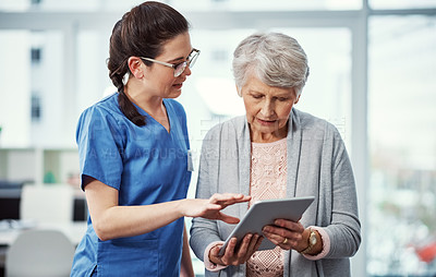 Buy stock photo Cropped shot of a young female nurse and her senior patient looking at a tablet in the old age home