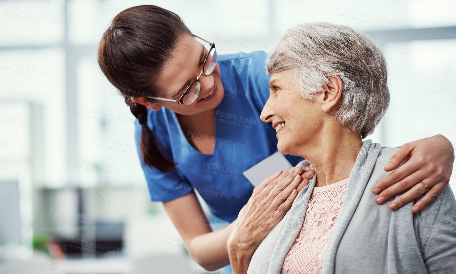 Buy stock photo Cropped shot of a young female nurse talking to her senior patient in the old age home