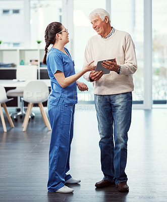 Buy stock photo Full length shot of a young female nurse and her senior patient looking at a tablet in the old age home