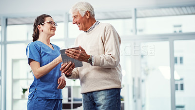 Buy stock photo Cropped shot of a young female nurse and her senior patient looking at a tablet in the old age home