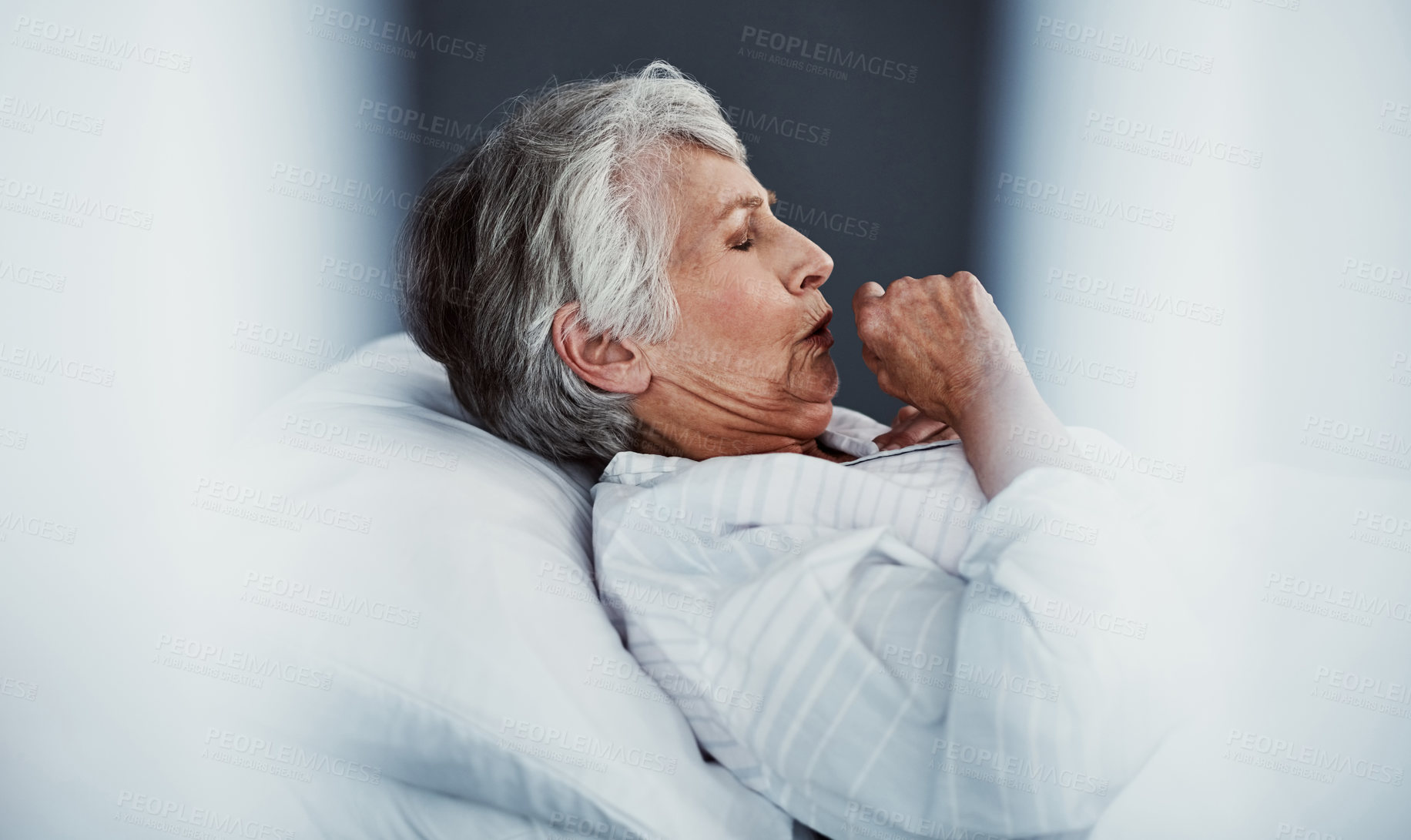 Buy stock photo High angle shot of a sickly senior woman coughing while lying in a hospital bed