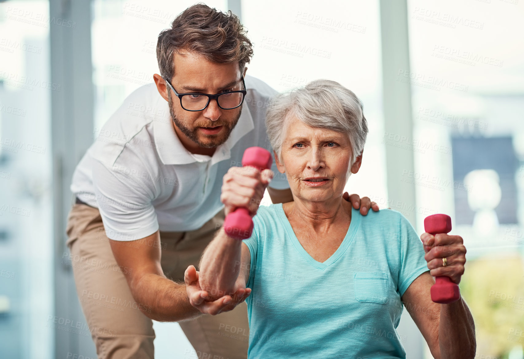 Buy stock photo Cropped shot of a senior woman working through her recovery with a male physiotherapist