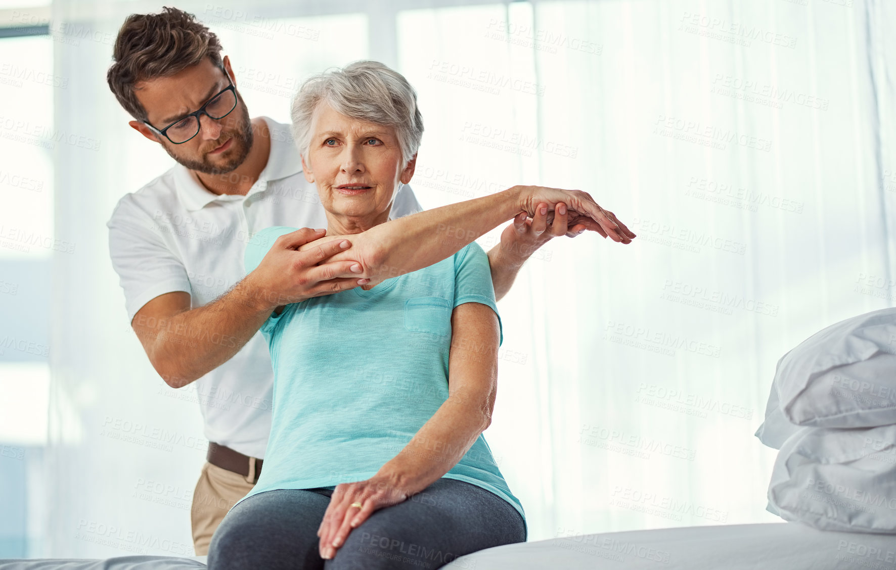 Buy stock photo Cropped shot of a senior woman working through her recovery with a male physiotherapist