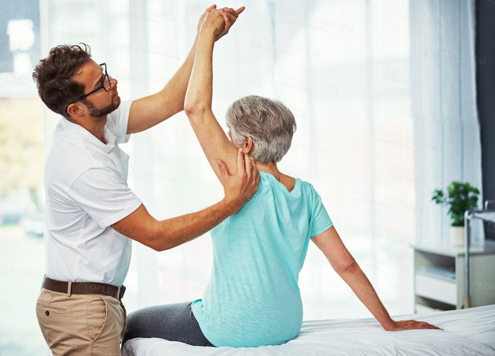 Buy stock photo Cropped shot of a senior woman working through her recovery with a male physiotherapist