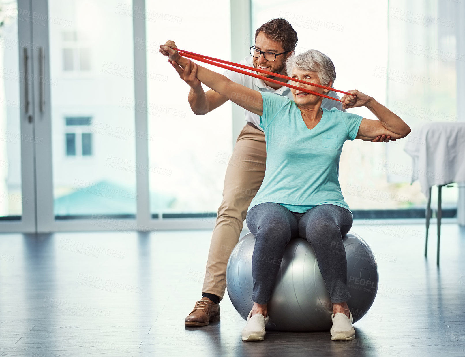 Buy stock photo Full length shot of a senior woman working through her recovery with a male physiotherapist