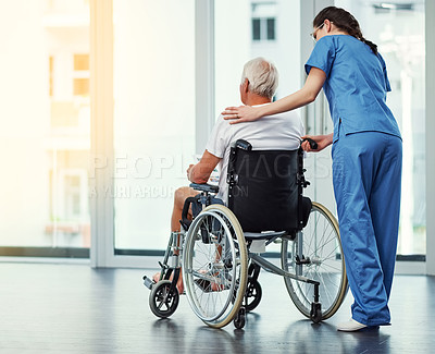 Buy stock photo Rearview shot of a young female nurse and her senior patient admiring the view through a window