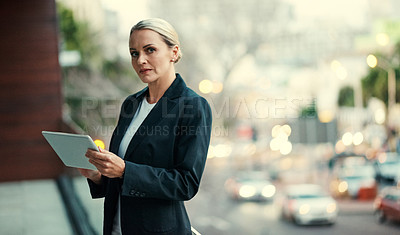 Buy stock photo Cropped portrait of an attractive mature businesswoman using her tablet while standing on the balcony of her office