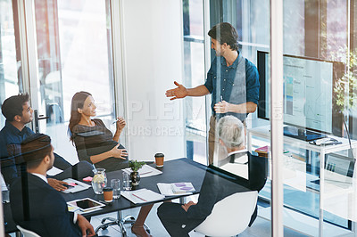 Buy stock photo High angle shot of a young businessman giving a presentation in the boardroom