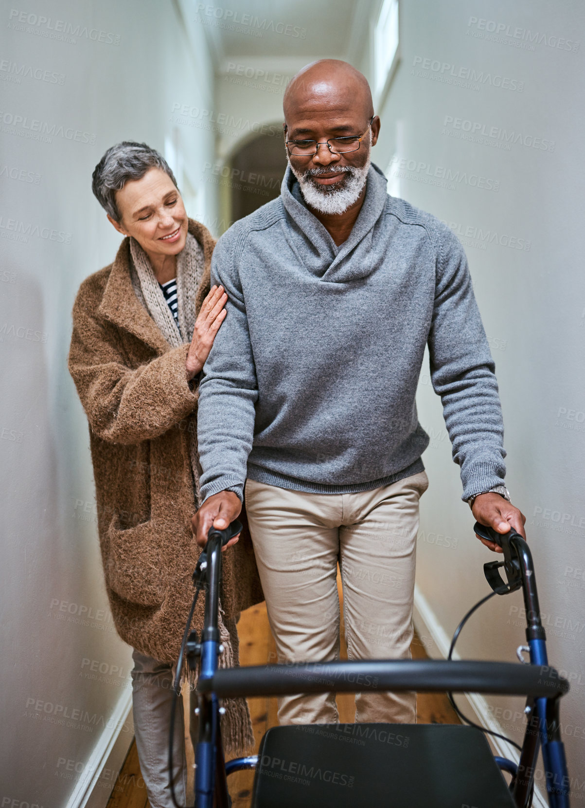 Buy stock photo Senior man, rehabilitation walker and wife in home recovery, training or love support. Black man, elderly couple and disability walk with care, motivation or help for strong body, legs or exercise