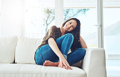 Buy stock photo Portrait of a happy young woman sitting on her sofa at home