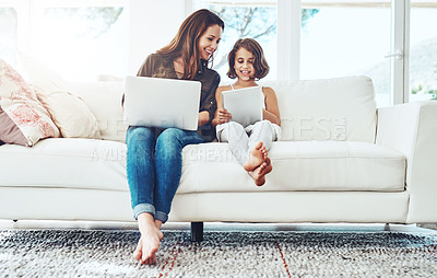 Buy stock photo Laptop, tablet and mother with child on sofa for streaming movies, happiness and bonding together in living room. Family, mom and young girl with technology for watching videos, film or relax in home