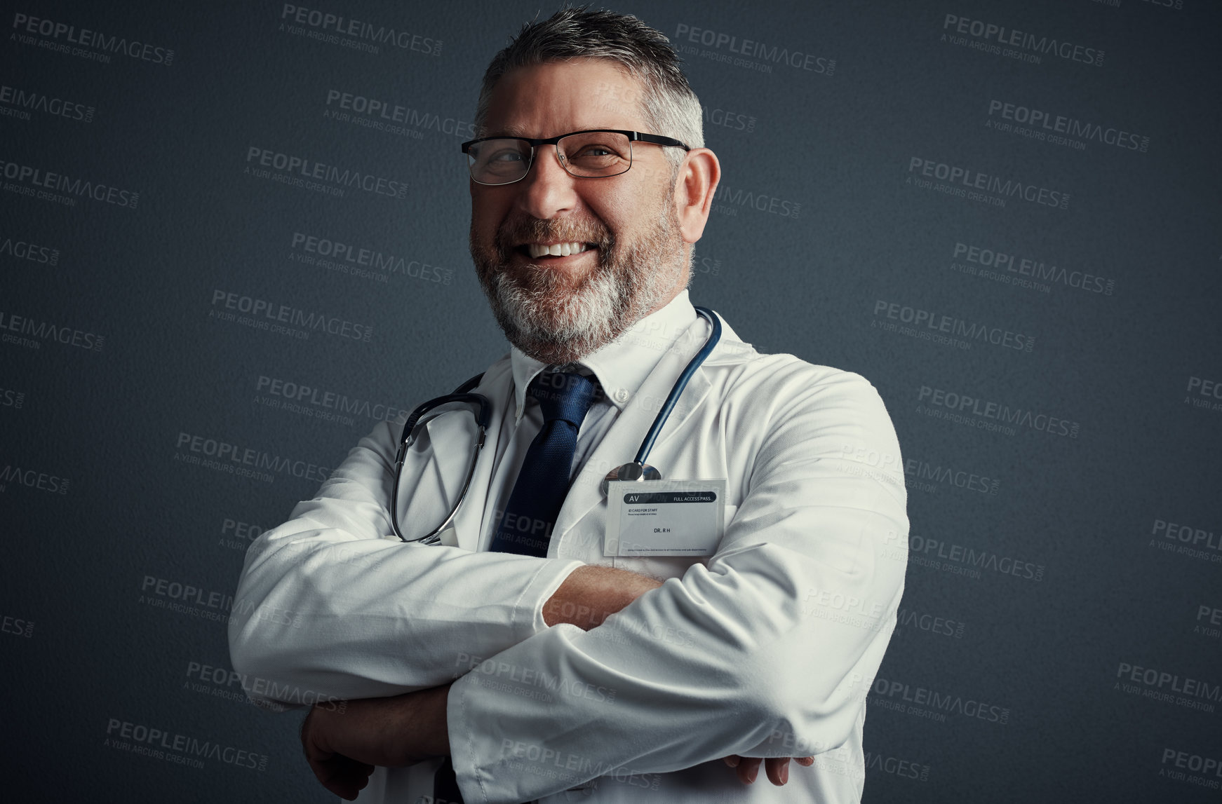 Buy stock photo Studio shot of a handsome mature male doctor looking thoughtful while standing with his arms folded against a dark background