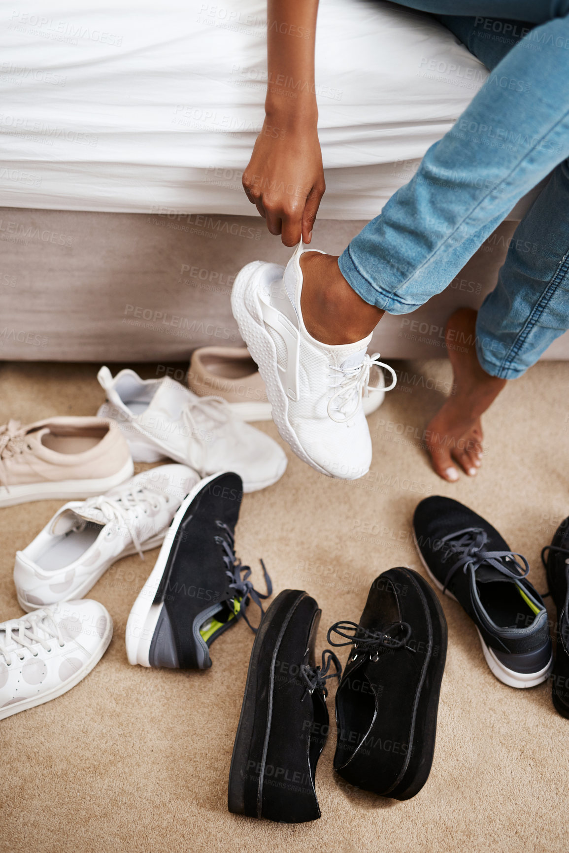 Buy stock photo Cropped shot of a woman trying on different pairs of shoes at home