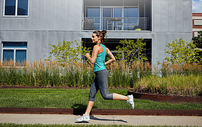 Buy stock photo Shot of an attractive young female runner exercising outdoors