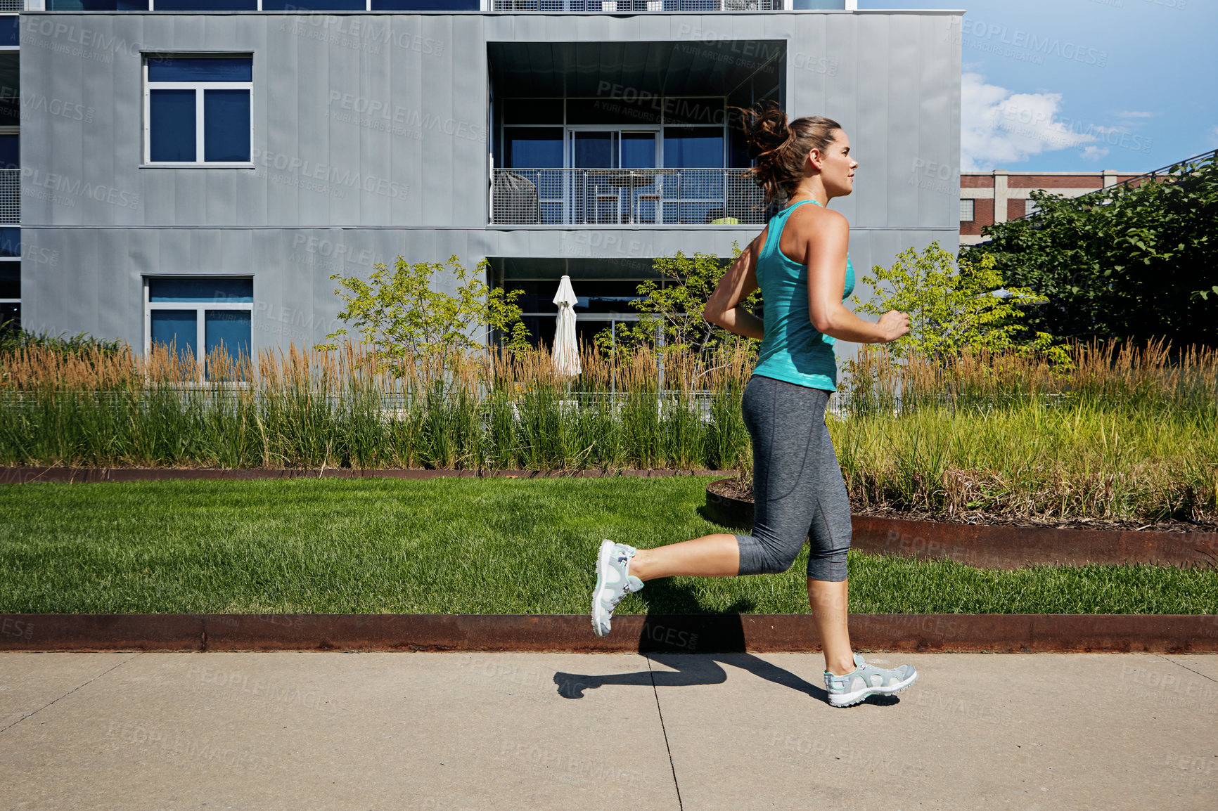 Buy stock photo Shot of an attractive young female runner exercising outdoors