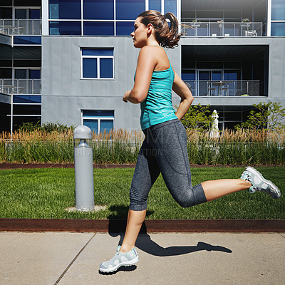 Buy stock photo Shot of an attractive young female runner exercising outdoors