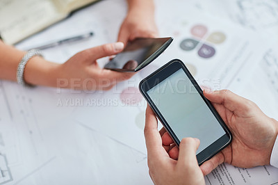 Buy stock photo Cropped shot of two businesspeople using their cellphones at a desk