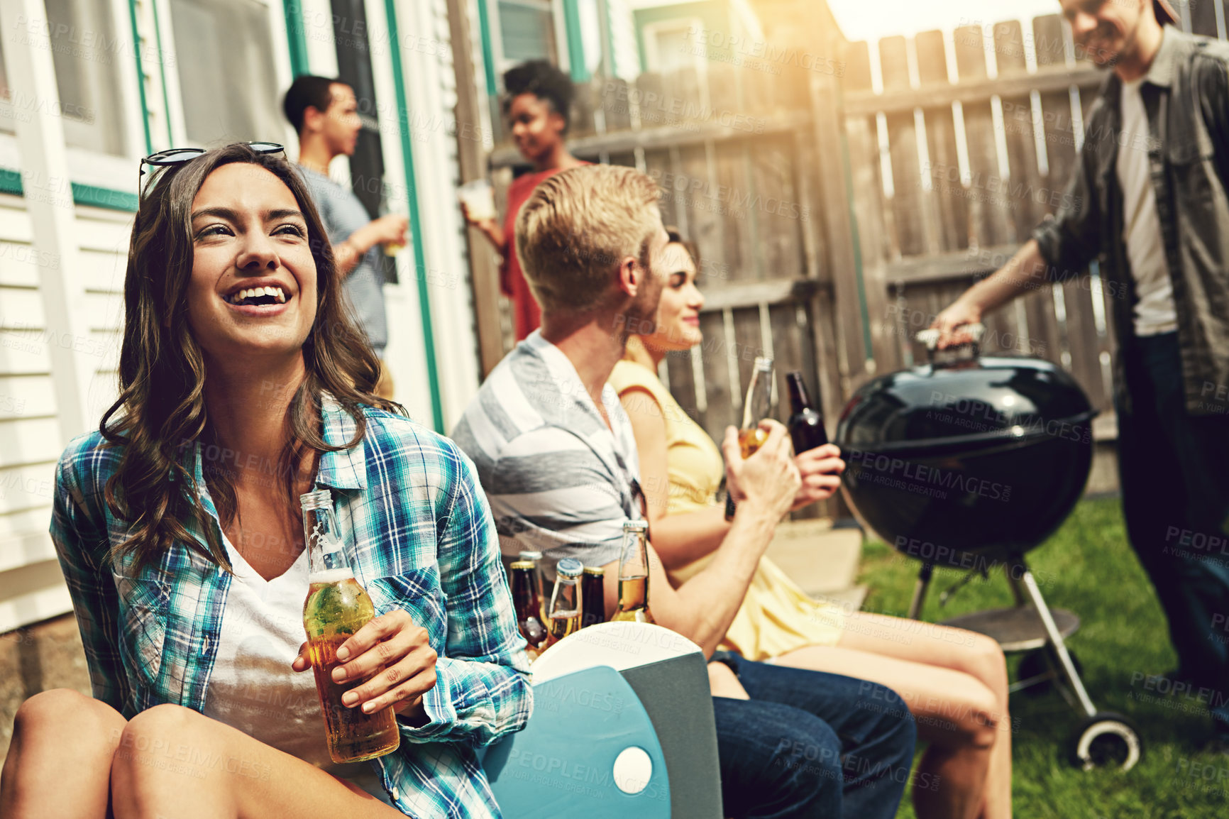 Buy stock photo Shot of a young woman enjoying a party with friends outdoors