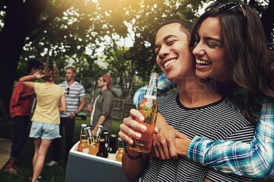 Buy stock photo Shot of a young couple enjoying a party with friends outdoors