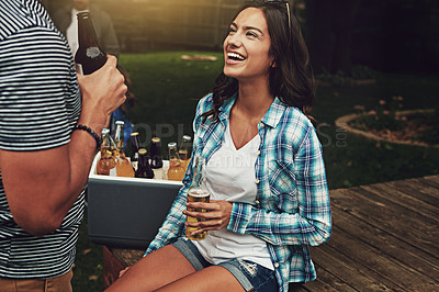 Buy stock photo Shot of a young woman chatting to a friend at a party outdoors