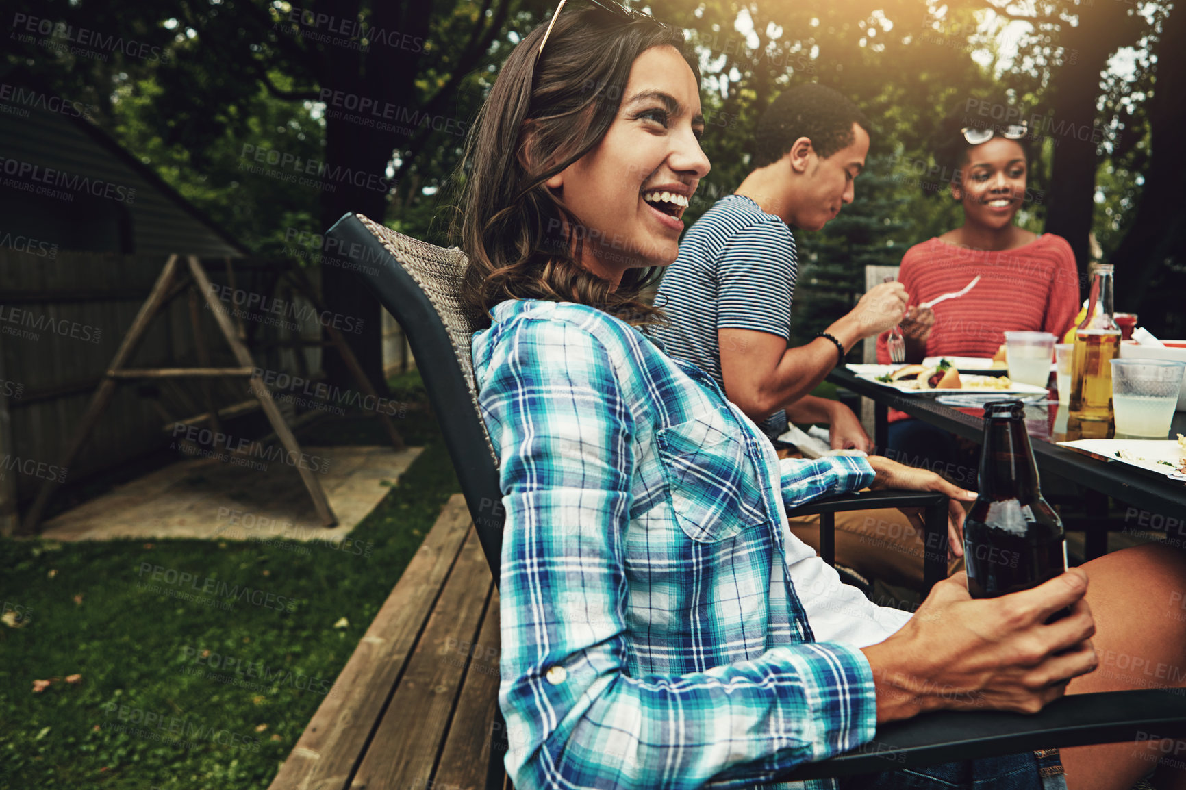 Buy stock photo Outdoor, backyard and woman with people, laughing and meal for gathering in weekend, break and reunion. Party, group and friends together with food, enjoy and cooking for celebration, lunch and drink