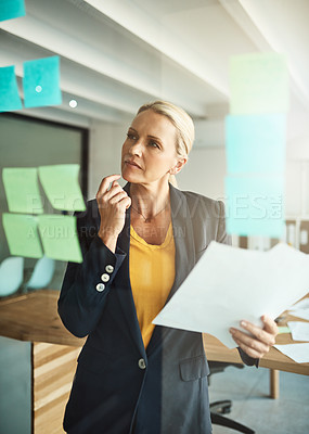 Buy stock photo Cropped shot of a mature corporate businesswoman planning on a glass wipe board
