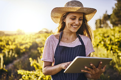 Buy stock photo Shot of a young woman using a digital tablet on a farm