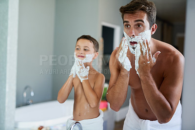 Buy stock photo Cropped shot of a handsome young man teaching his son how to shave in the bathroom