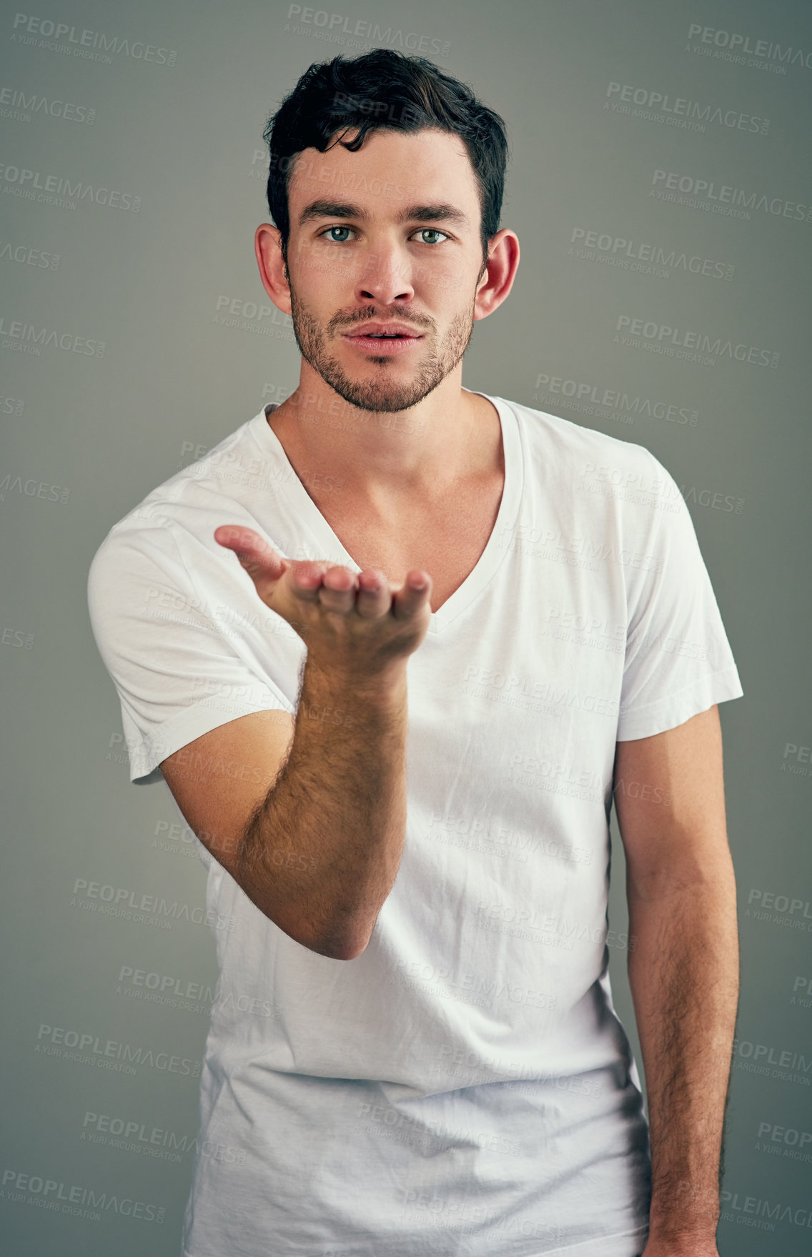 Buy stock photo Portrait, studio and man with blow of kiss, romance and flirting for date in Valentines Day and gesture. Grey background, relax and hand for offer of love, gratitude and emoji for care and affection