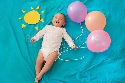 Buy stock photo Conceptual shot of a baby girl holding balloons against a blue background