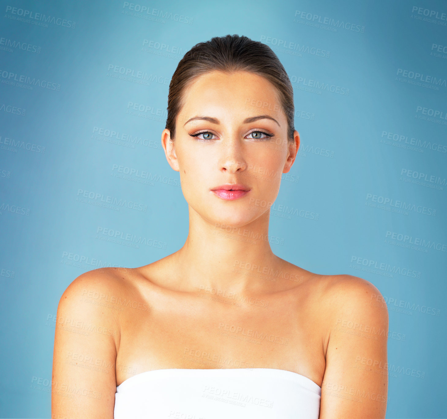 Buy stock photo Studio portrait of a beautiful young woman posing against a blue background